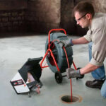 Technician inspecting a drain with camera